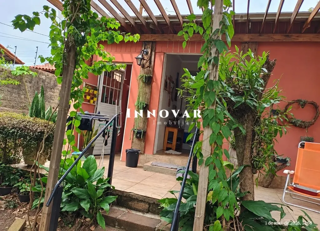 Entrada da casa do sítio rural à venda no bairro Campestre, São Leopoldo, com pérgola de madeira, paredes em tom terracota e muitas plantas